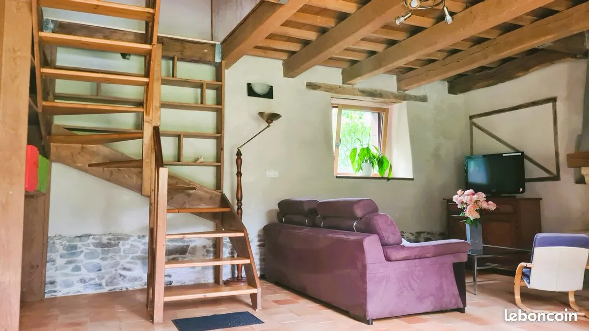 Séjour du gîte de Pleugueneuc avec escalier en bois et poutres apparentes
